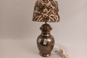 Zilverkleurige soort Urne lamp met koperkleurige versieringen op en bruin/beige gevlochten kap